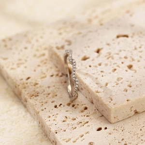 Detailed view of s925 silver wavy ring with small diamonds on textured stone blocks