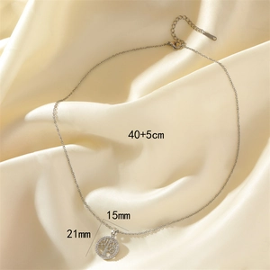 Detailed view of silver tree of life pendant with zircon on champagne silk background