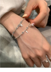 Detail view of ethnic silver fish bracelet with freshwater pearls and layered ring