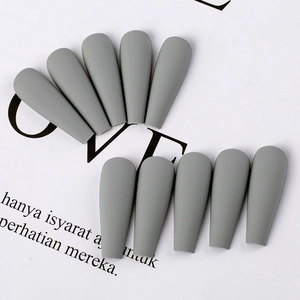 Detail of matte grey coffin press-on nails with long trapezoid shape on white backdrop