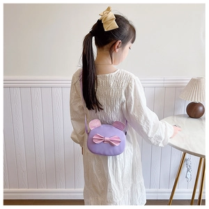 Detail of purple children crossbody bag with pink sequin bow and cute round ears