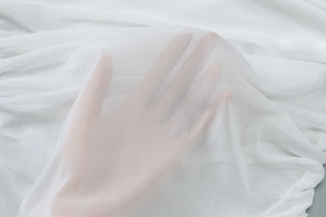 Gros plan sur un tissu en maille blanche respirante à la texture semi-transparente