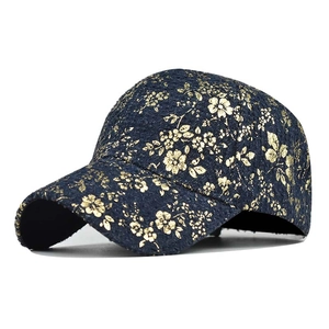 Detailed close-up of navy blue hip hop cap with gold floral embroidery and 6-panel crown