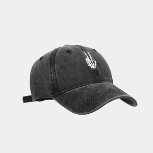 Detail of white skeleton hand embroidery on black washed denim retro baseball cap