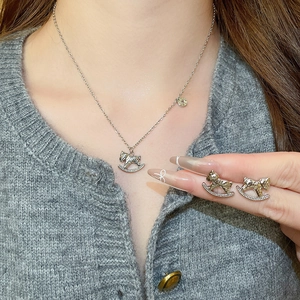 Vue détaillée du collier cheval à bascule et des boucles d'oreilles avec zircons