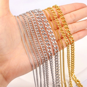 Gold and silver stainless steel chains in various sizes displayed on a hand for scale