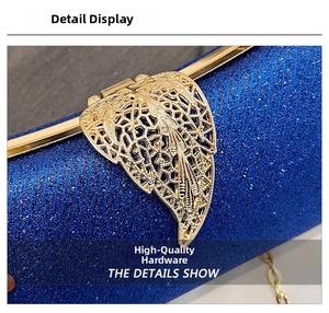 Detail of high-quality golden leaf metal clasp on shimmering navy blue evening clutch bag