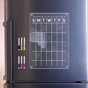 Acrylic weekly planner on a fridge with colorful markers and notes for home organization