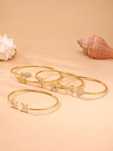 Détail du lot de joncs dorés 18 carats avec motif étoile de mer, coquillage et zircons 5A