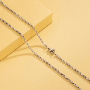 Detailed view of a silver stainless steel box chain necklace with a secure lobster clasp