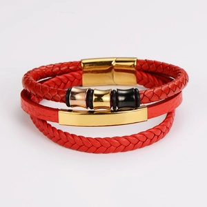 Detail of red multilayer braided leather bracelet with gold bars and magnetic buckle