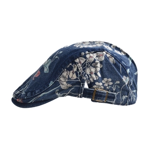 Detail of washed denim ivy cap with vintage floral print and bronze metal buckle