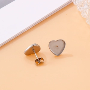 Gros plan de clous d'oreilles en forme de cœur avec fermoirs papillon pour création de bijoux