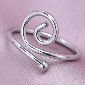 Macro shot of silver 304 stainless steel spiral ring on elegant purple silk fabric