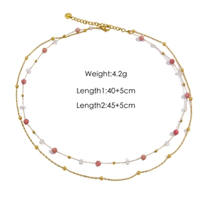 Double-layered beaded necklace with pink stones and dolphin pendant on white background