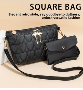 Detail of heart quilted black PU leather bag with golden swan motif and mini pouch