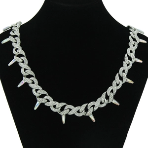 Close-up of silver Cuban link chain with rhinestones and iridescent spike pendants