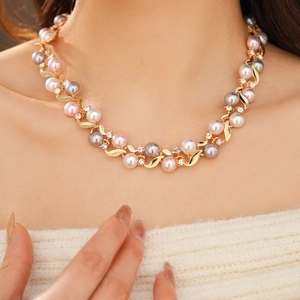Collier vintage doré avec perles blanches et grises et cristaux porté par un mannequin chic