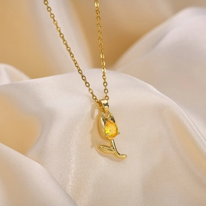 Macro detail of a golden tulip pendant with a sparkling yellow teardrop zircon gem