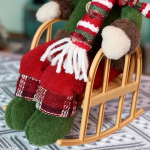 Vintage Christmas Santa doll sitting on a rocking chair with plaid outfit and white scarf