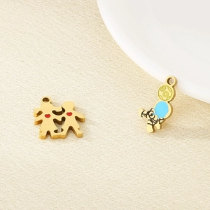 Detail of golden stainless steel heart and astronaut charms for DIY jewelry on cloth