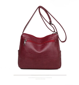 Rear view of large burgundy crossbody bag showing multi-zipper pockets and lychee texture