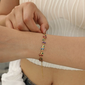 Gold cherry charm bracelet with colorful sparkling gemstones for women on model wrist