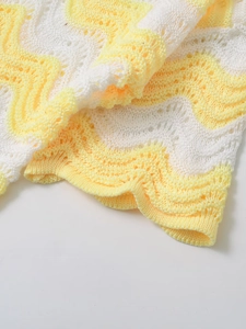 Detailed close-up of yellow and white wavy knit texture and crochet craftsmanship