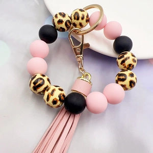 Detail of pink and black leopard wood beads silicone keychain bracelet with tassel