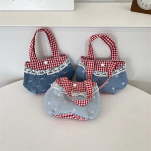 Dettaglio di mini borse in denim fatte a mano con pizzo e motivi a quadri rossi