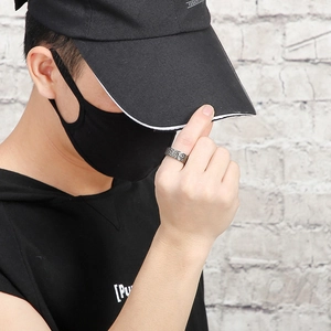 Street style view of a wide men's titanium ring with hammered texture in black metal