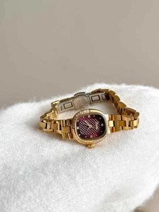 Detail of a ladies gold square watch with purple textured dial and zircon bezel
