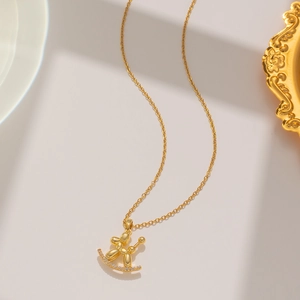 Close-up of golden balloon dog pendant on a sparkling diamond-set base with O-chain