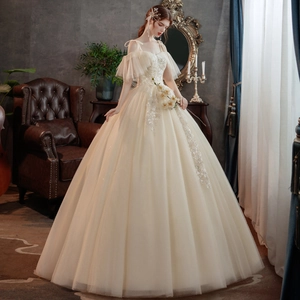 Elegantes champagnerfarbenes Brautkleid mit floraler Spitzenstickerei und vollem Tüllrock