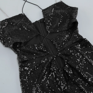 Détail de robe noire à paillettes avec bretelles chaîne argentées et fermeture éclair