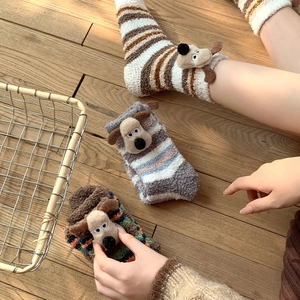 Detail of coral fleece winter socks with 3D cartoon puppy and striped textures