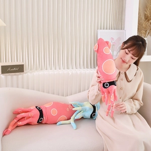 Detail of plush squid doll featuring soft pink and teal fabric with orange polka dots
