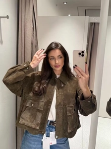 Close-up of a brown faux suede bomber jacket with large utility pockets and zip closure