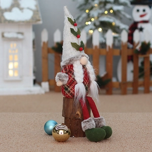 Christmas sitting gnome plush with white hat and red plaid outfit on wood log