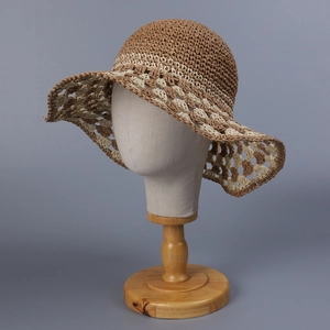 Detail of hand-crocheted hollow pattern on wide brim bohemian sun hat in brown and beige