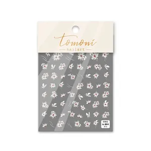 Macro detail of white floral 5D nail art stickers with red centers in retail packaging