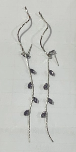 Detailed view of silver leaf tassel earrings featuring purple marquise-cut crystals