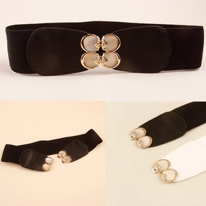Detail of elastic waist belts featuring gold four-leaf clover buckles with pearl inlays