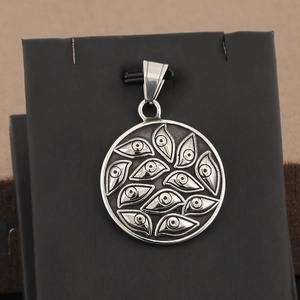 Close-up of vintage stainless steel square pendant with embossed evil eye motif for men