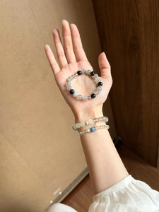 Detailansicht von handgehaltenen und am Handgelenk getragenen Naturkristall-Perlenarmbändern.