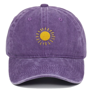 Close-up of yellow sun embroidery on a vintage washed purple cotton baseball cap