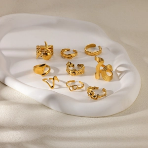 Detailed view of nine gold vintage-style adjustable rings with sea motifs on a tray