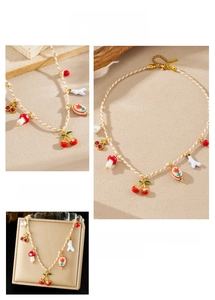 Detail of handmade woven necklace with cherry, mushroom, and floral enamel charms