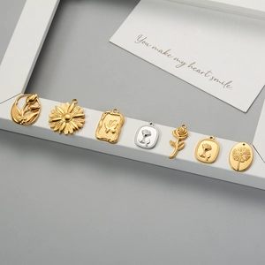Detailed view of assorted gold and silver floral and butterfly charms on a white frame