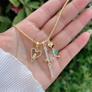 Detail of 18K gold plated rope chain with heart, winged sword, and rose pendants